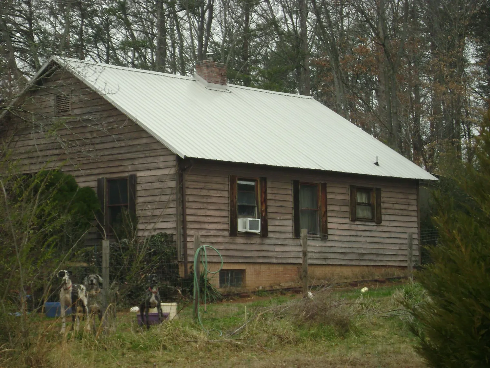 White metal roof on an old wood sided farmhouse, from a Metal Roof Installation job in Hastings
